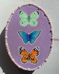 three butterflies painted on a purple background